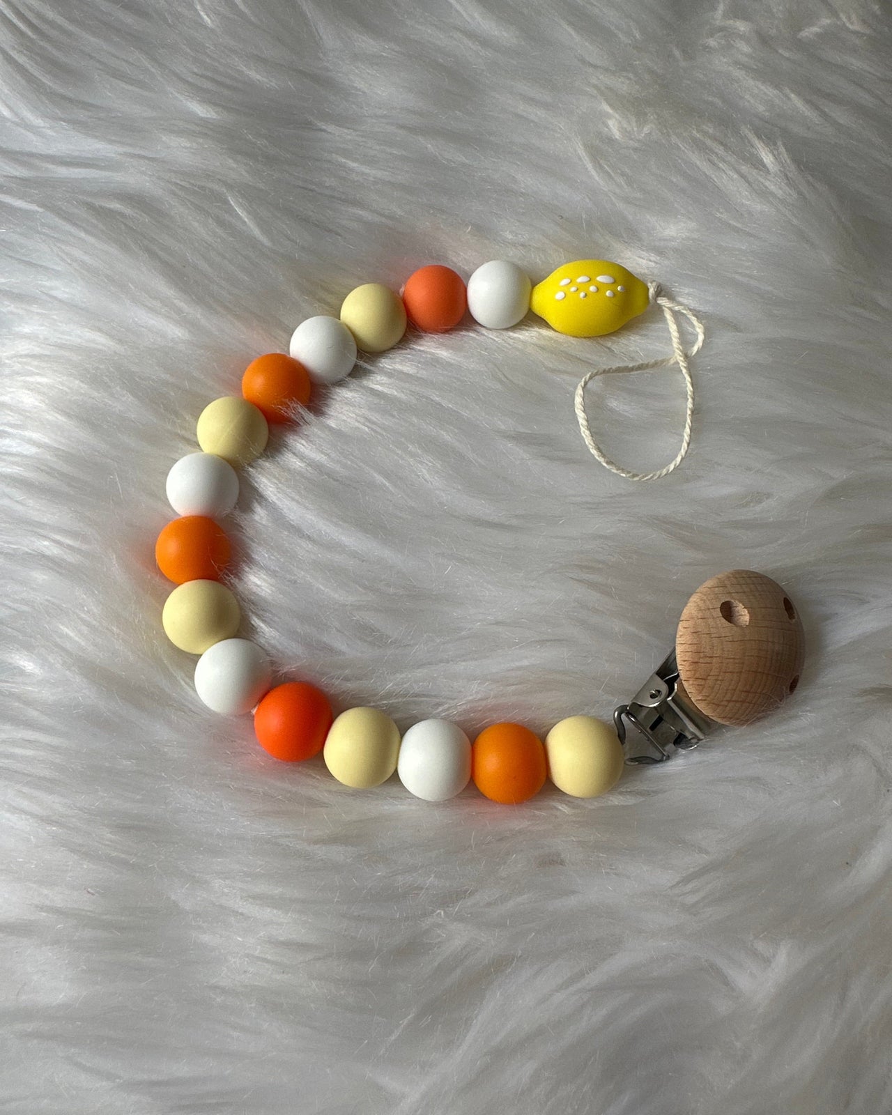 Attache sucette citron en silicone doux, sécurisé et lavable, accessoire pratique pour bébé.