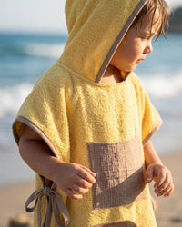 Poncho de plage miel doré pour enfant avec capuche et poche, absorbant et doux, fabriqué à la main au Maroc.